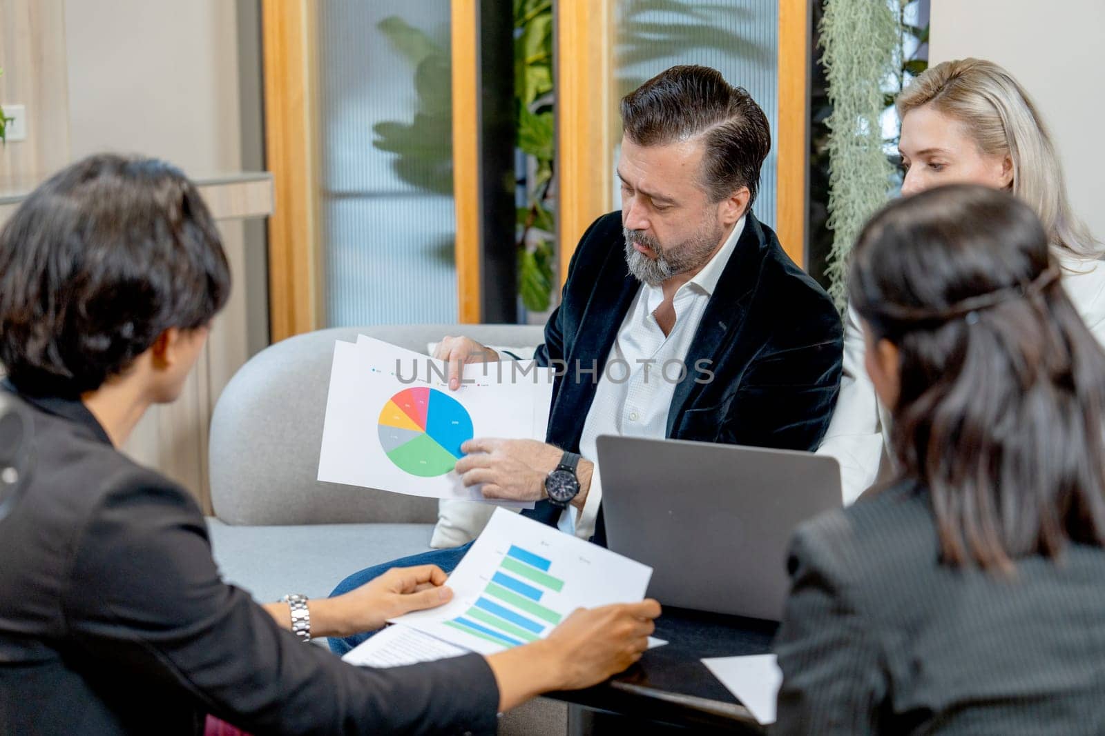 Close up of Caucasian business man look like manager explain about his work using graph on paper to the colleagues.