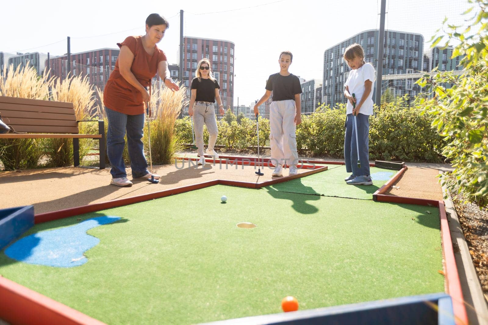 family playing mini golf on a cruise liner. Child having fun with active leisure on vacations. by Andelov13