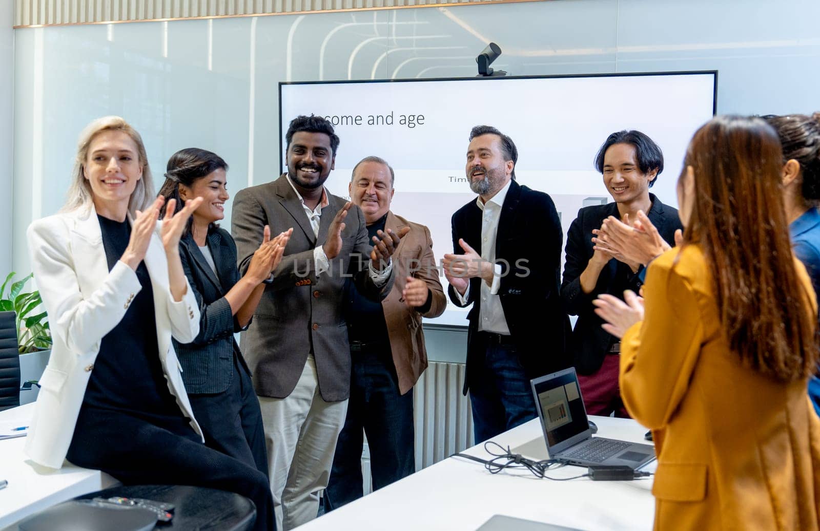 Crowd of business people stand and crap hands to celebrate the success of project in conference of meeting room.