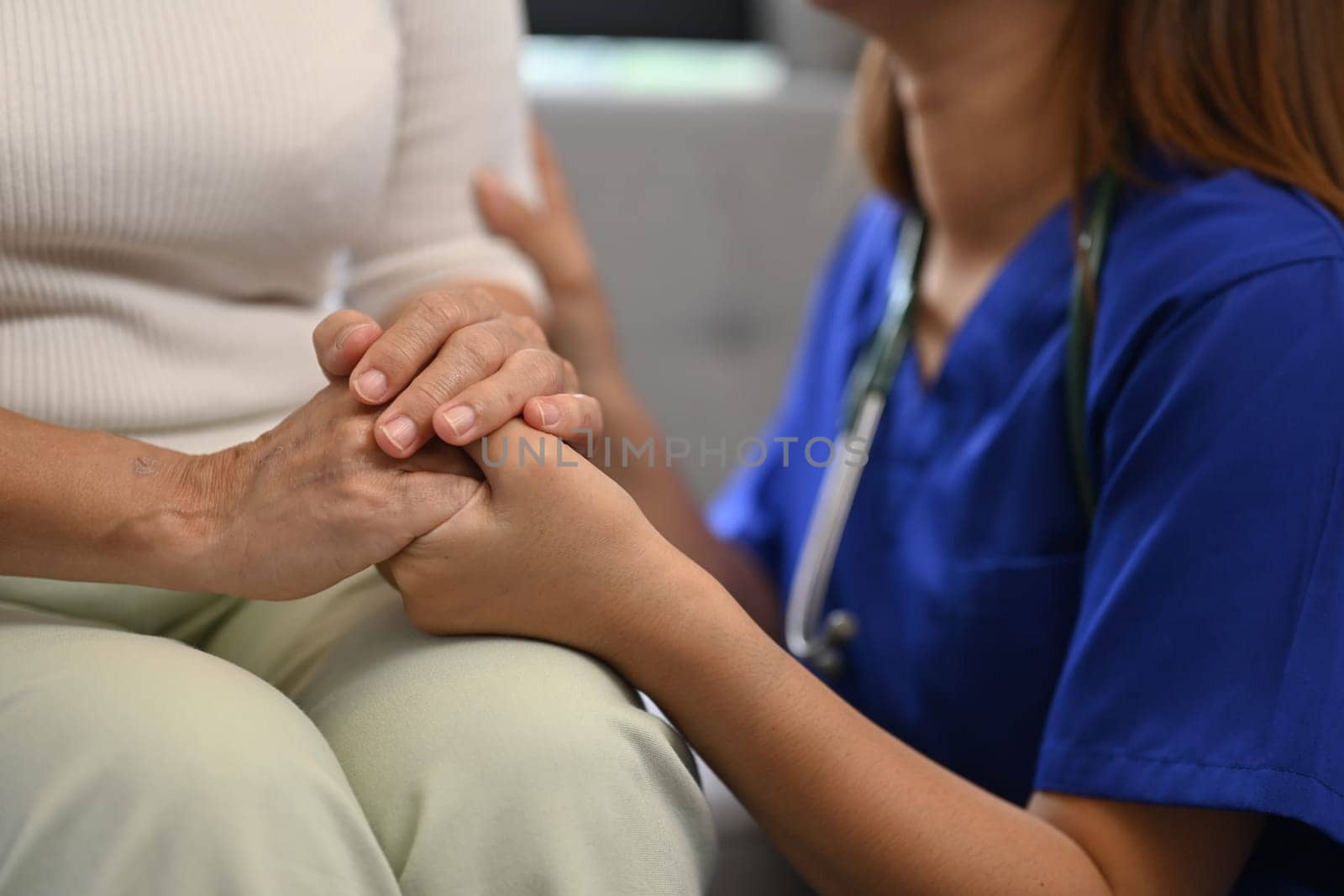 Cropped shot of caring nurse holding senior woman hands for hope and supporting. Elderly healthcare concept