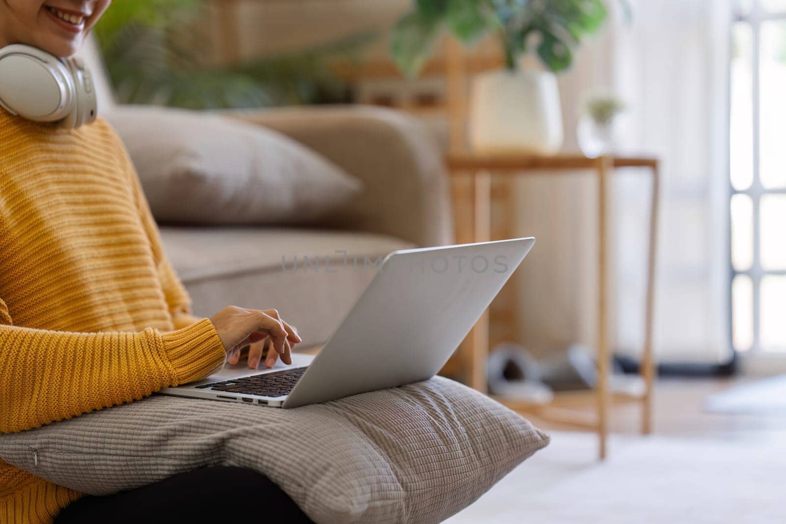 Young woman sitting on floor at home working with laptop and document by itchaznong