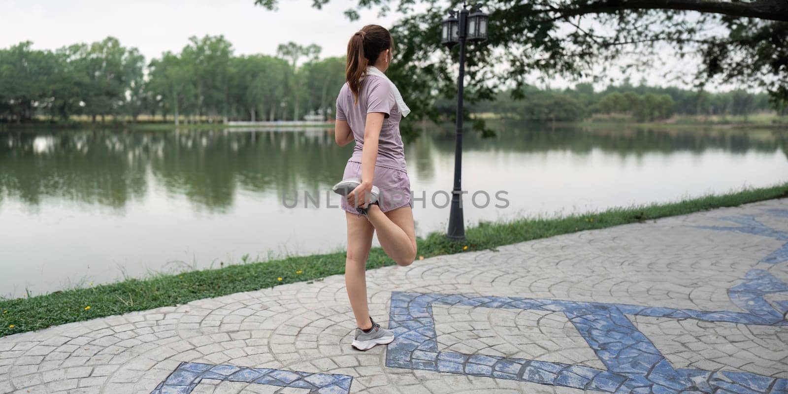 Woman in sport clothes stretch before going for running in the morning.