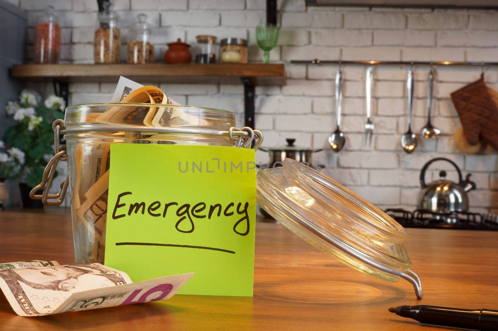 A glass jar for Emergency fund with cash.