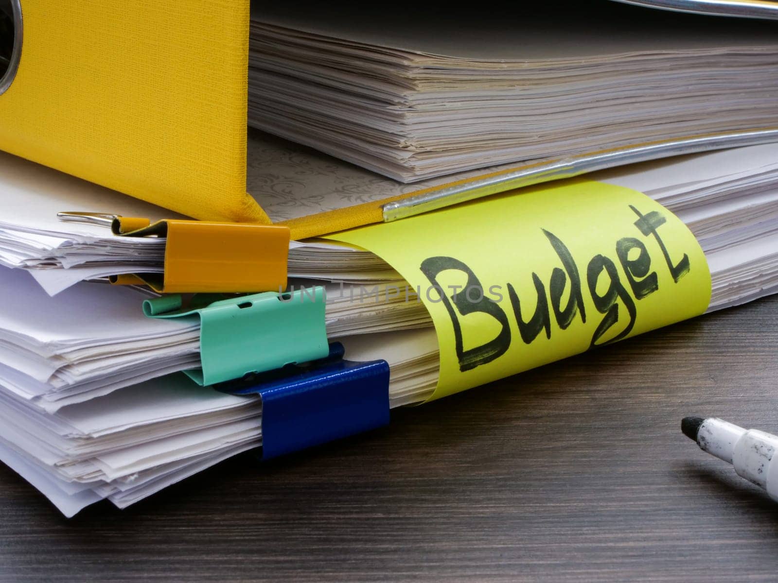 A folder with stack of papers and the word company budget. by designer491