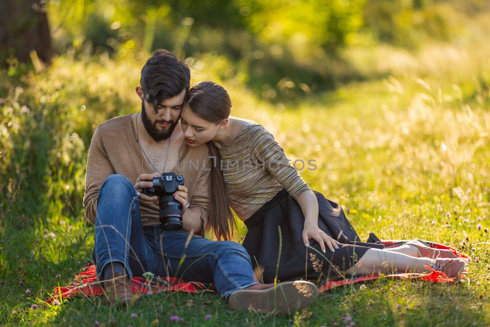 young couple looking at photos on a camera by zokov