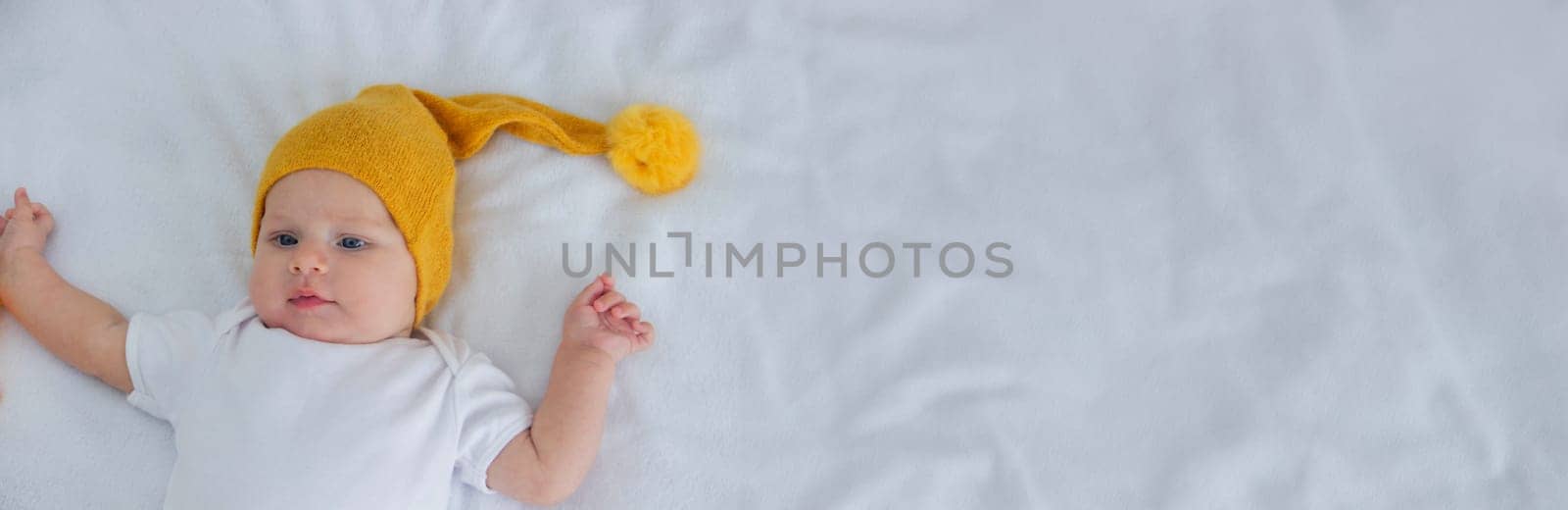 the child lies on a white background with a small bear.