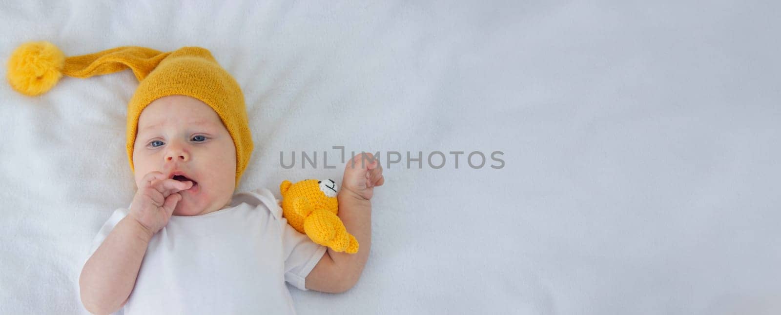 the child lies on a white background with a small bear.