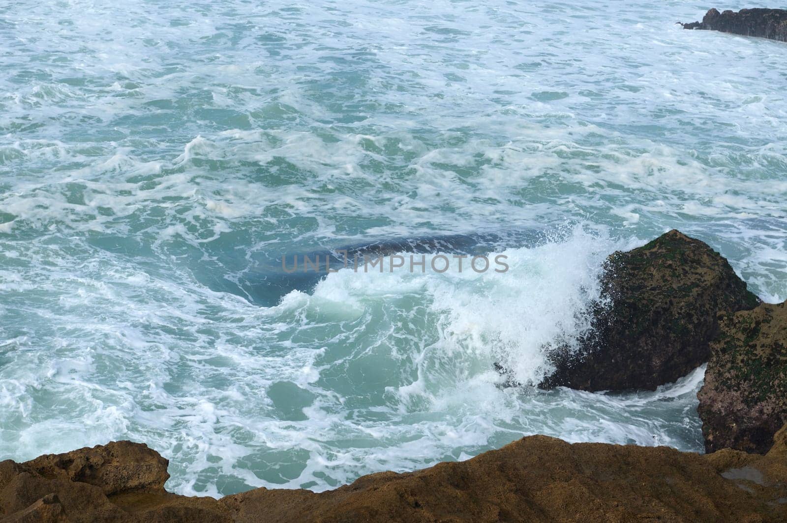View from above waves breaking on headland and making whirlpool. Copy advertising space. Atlantic ocean. Nature backdrop by artgf