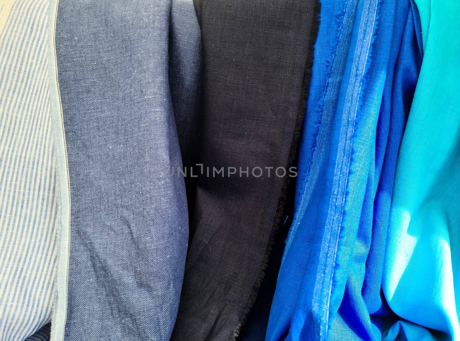 Samples of cloth and fabrics in different colors found at a fabrics market.