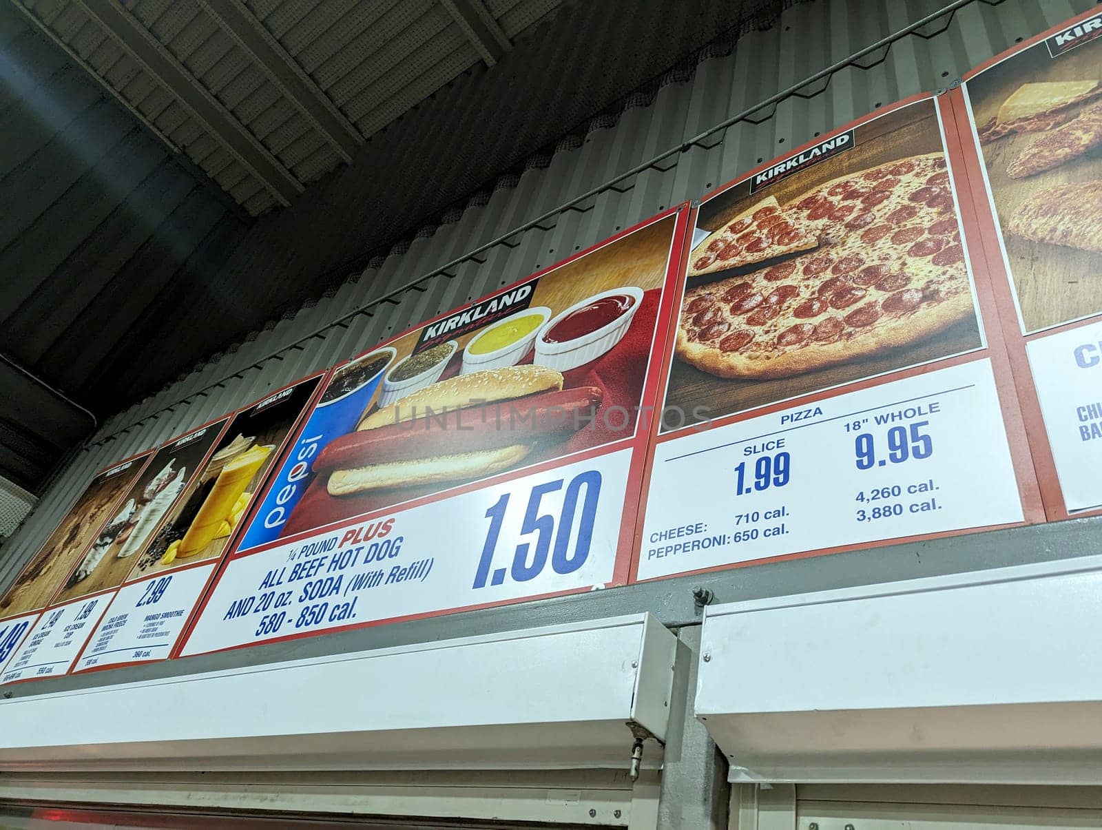 Honolulu - December 29, 2022:  Menu board at a Costco food court, with prices and pictures of the available items. The photo shows the hot dog plus, pizza, and drinks sections of the menu, with calorie counts and product information. 