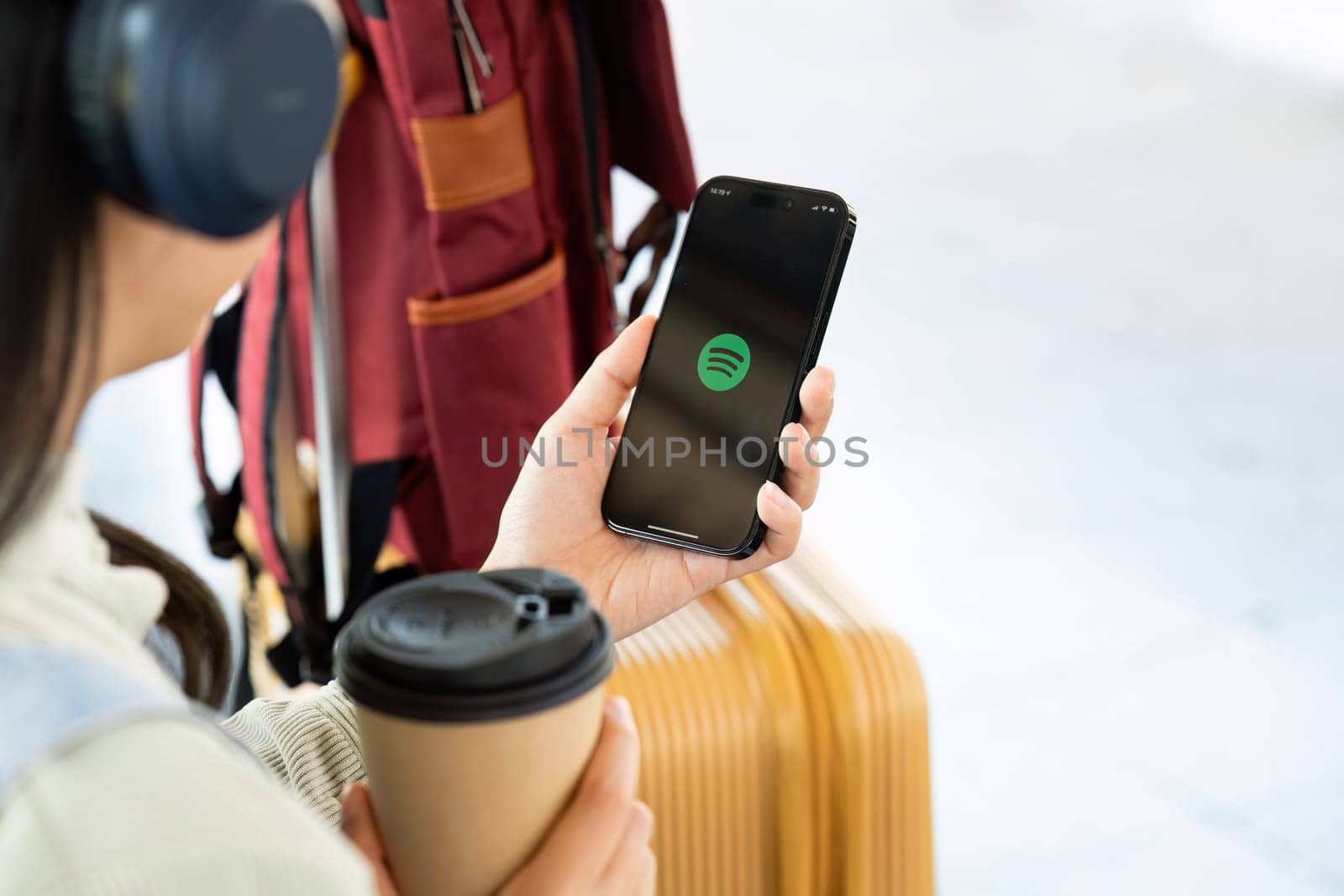 CHIANG MAI, THAILAND - DECEMBER 20, 2023: Person holding a brand new Apple iPhone 14 Pro with Spotify logo on the screen. Spotify is a popular commercial music streaming service. by itchaznong