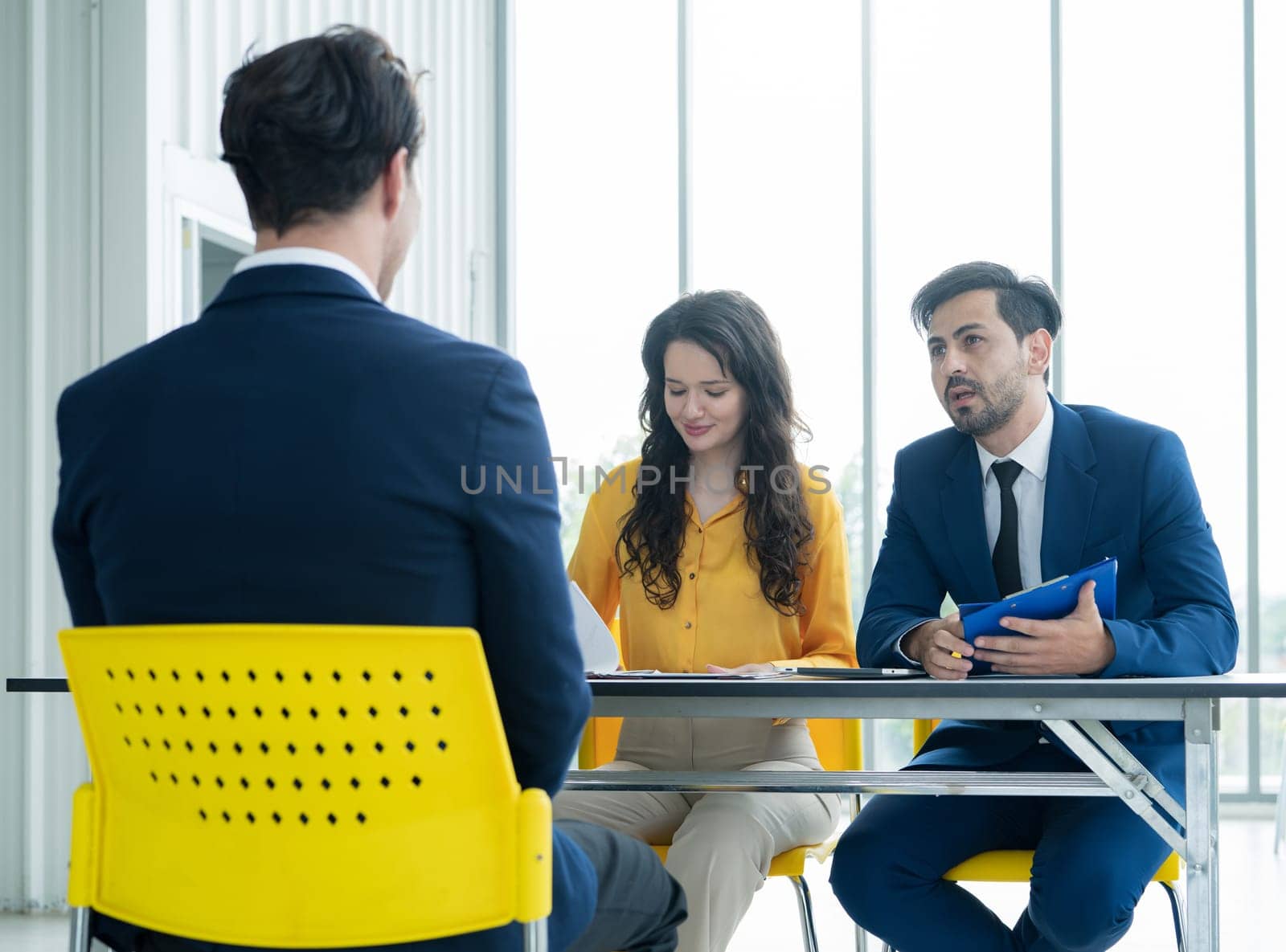 Job interview concept. Diverse hr team doing job interview with a man in business office. Human resources team interviewing a potential job candidate. Hiring, employment, and recruitment concept. by Fahroni