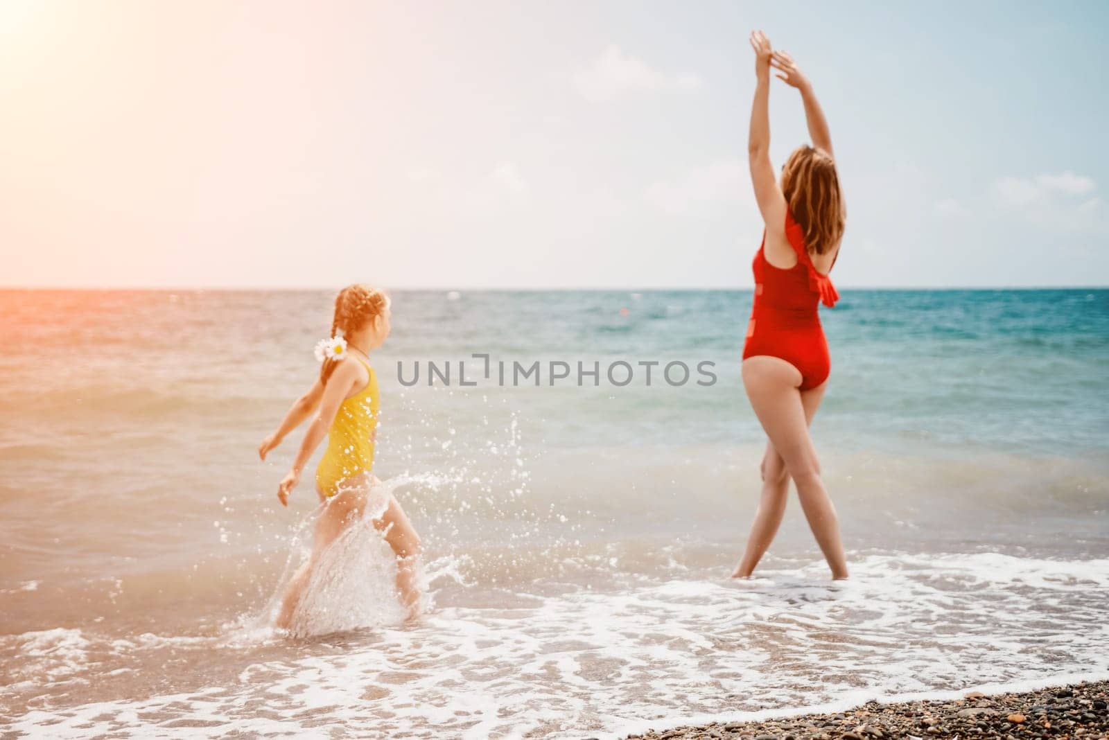 Happy loving family mother and daughter having fun together on the beach. Mum playing with her kid in holiday vacation next to the ocean - Family lifestyle and love concept by panophotograph