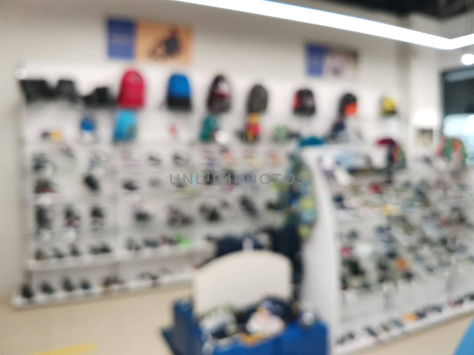 Blur Supermarket sale kid shoes on shelves background. Many kid shoes sale on the shelf in a supermarket, as blurred effect background. Kid shoes and accessories section.