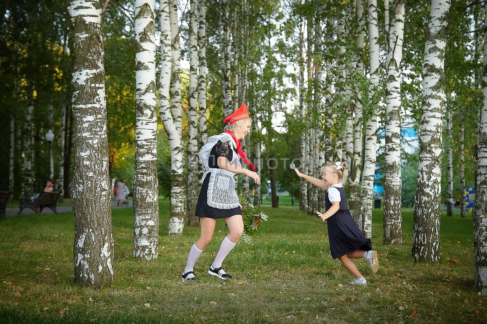 Young and adult schoolgirl on September 1, mother and daughter having fun and joy. Generations of schoolchildren of USSR and Russia. Female pioneer in red tie and October girl in modern uniform