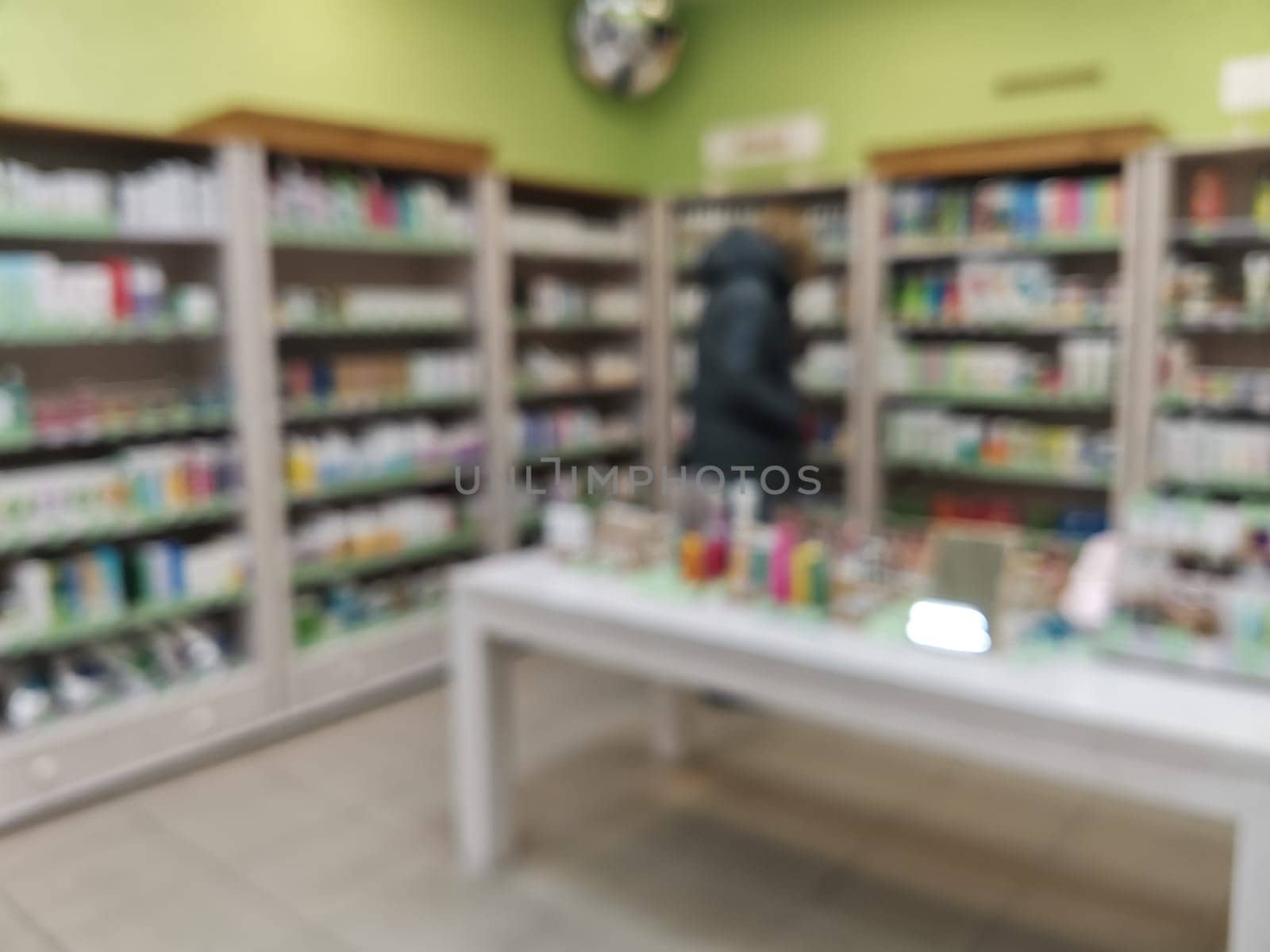 Blurred background with shelves with skin and hair care products in a cosmetic store. Rack with shelves with cosmetics in a store.