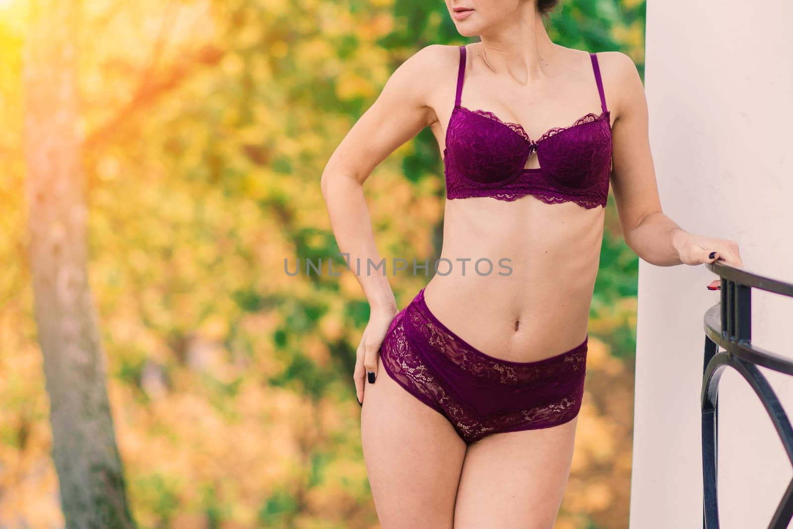 Beautiful young woman in lingerie posing in autumn forest