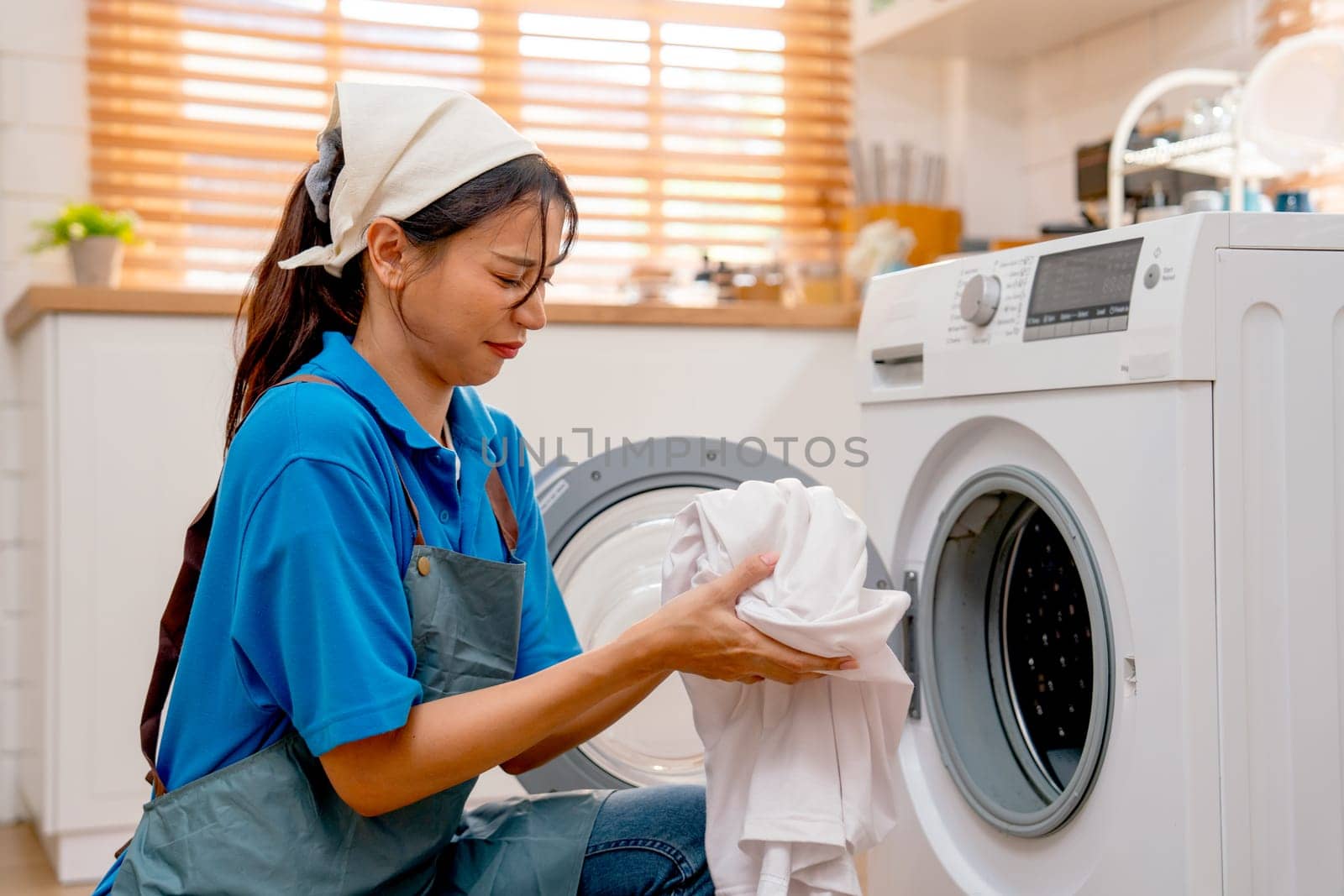 Asian housekeeper or housemaid action of smelly from cloth before put it to washing machine during process of clean and manage the customer house.