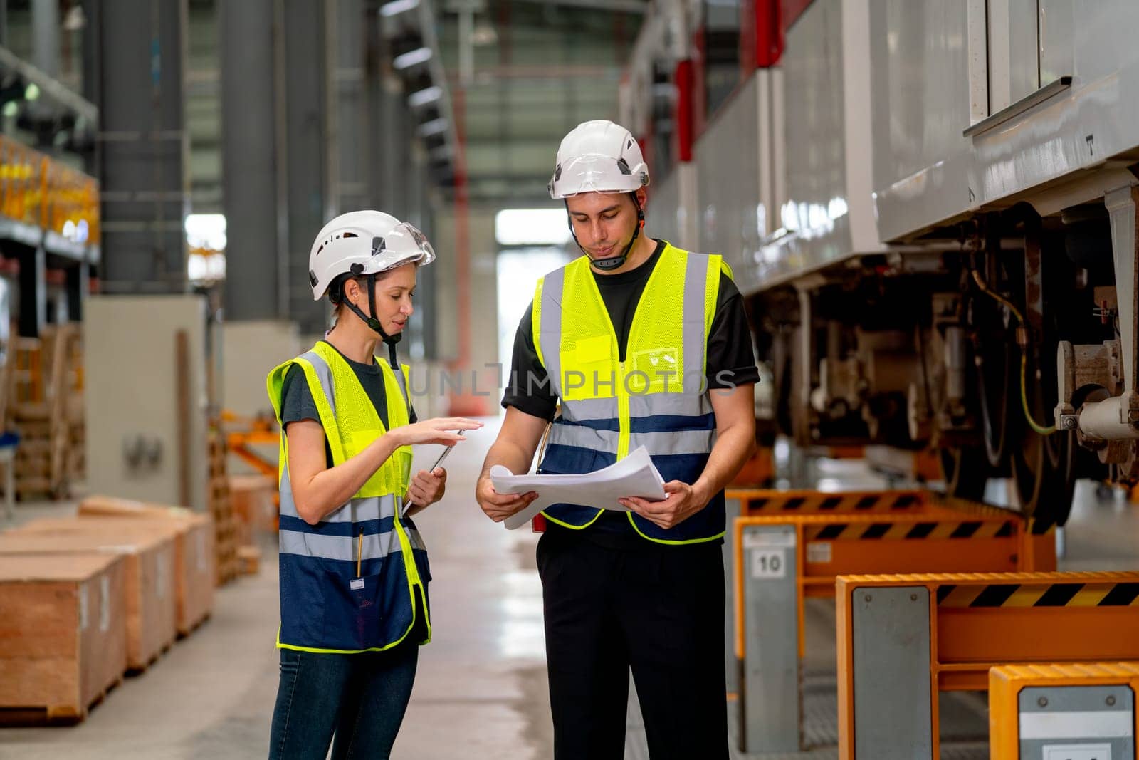 Two professional engineer or technician worker discuss about work and stand near the train in workplace area.