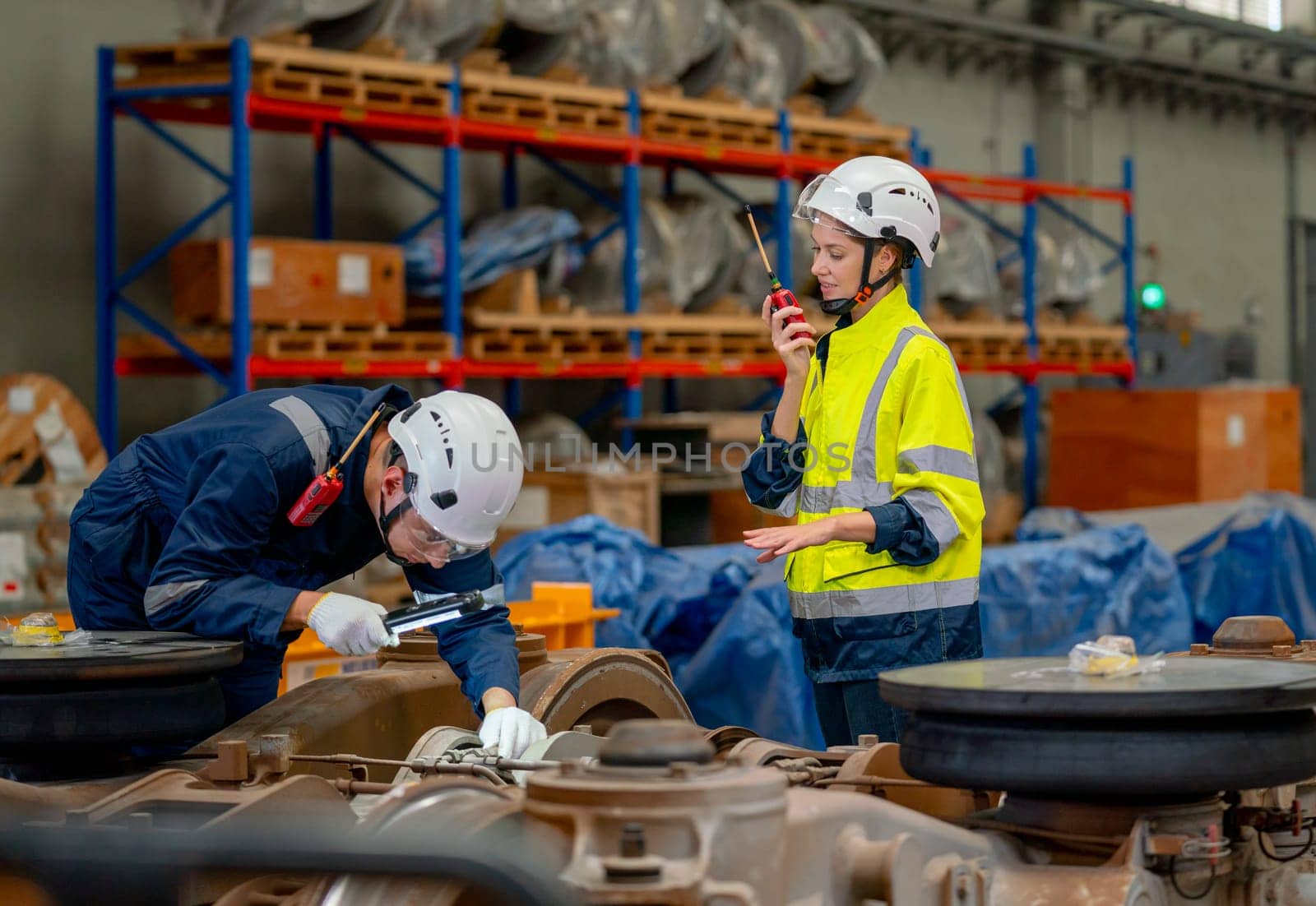 Professional technician or engineer try to check and fix the problem part of electric train and work with factory worker use walkie talkie to contact co-worker team in workplace area. by nrradmin