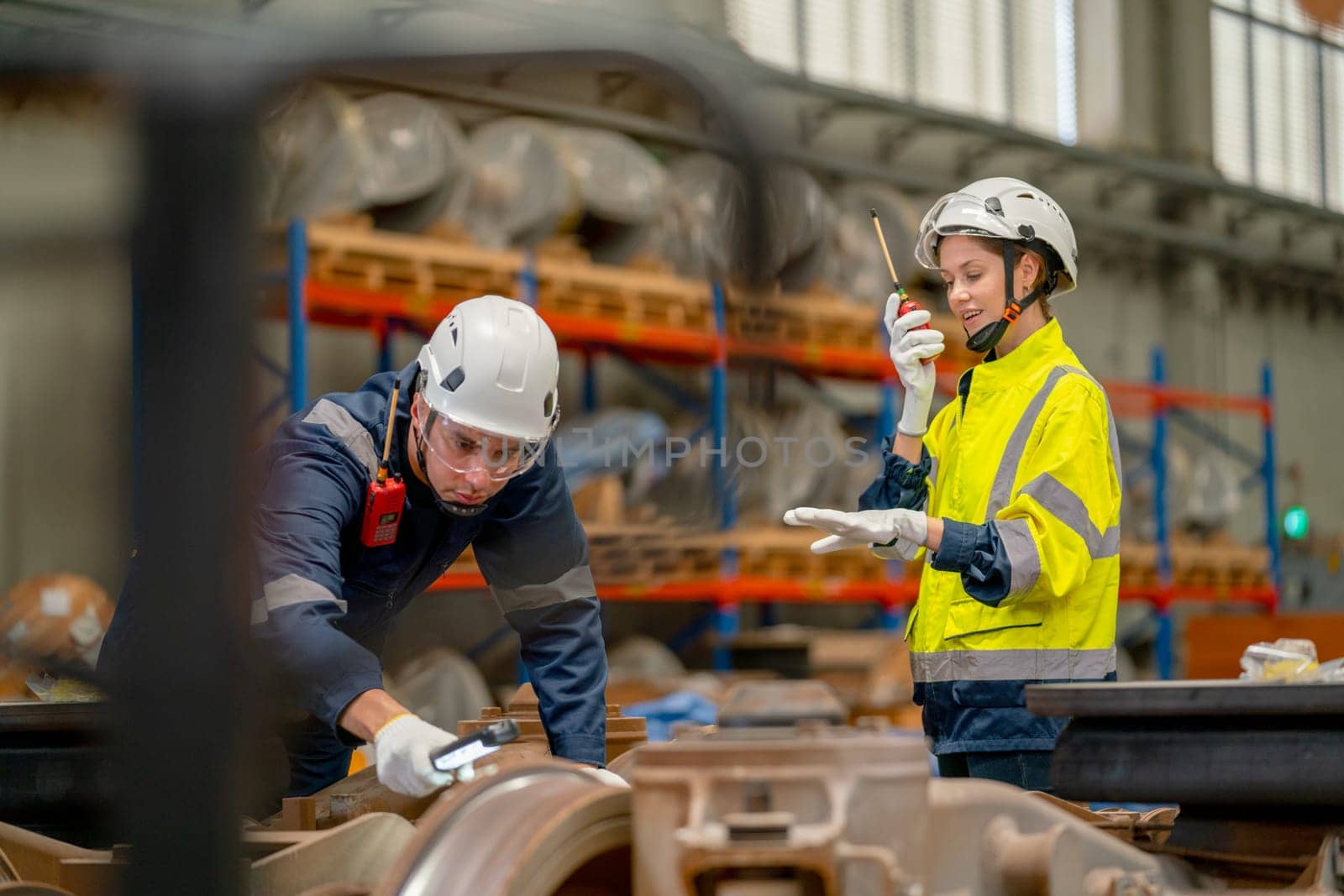 Professional technician or engineer try to check and fix the problem part of electric train and work with factory worker use walkie talkie to contact co-worker team in workplace area.