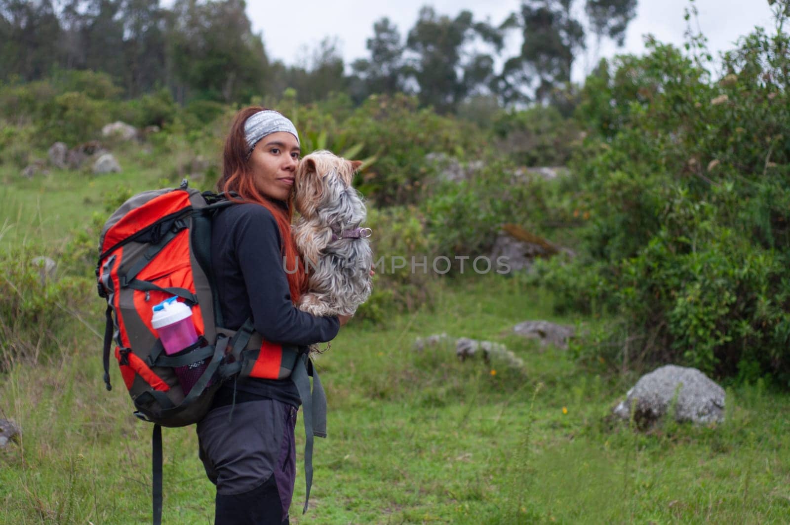copy space mountain travel lover woman looking at camera with her dog in her arms by Raulmartin
