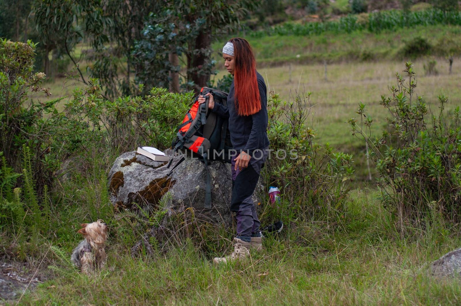 latina girl talking to her puppy before going on a long walk in the mountains. High quality photo