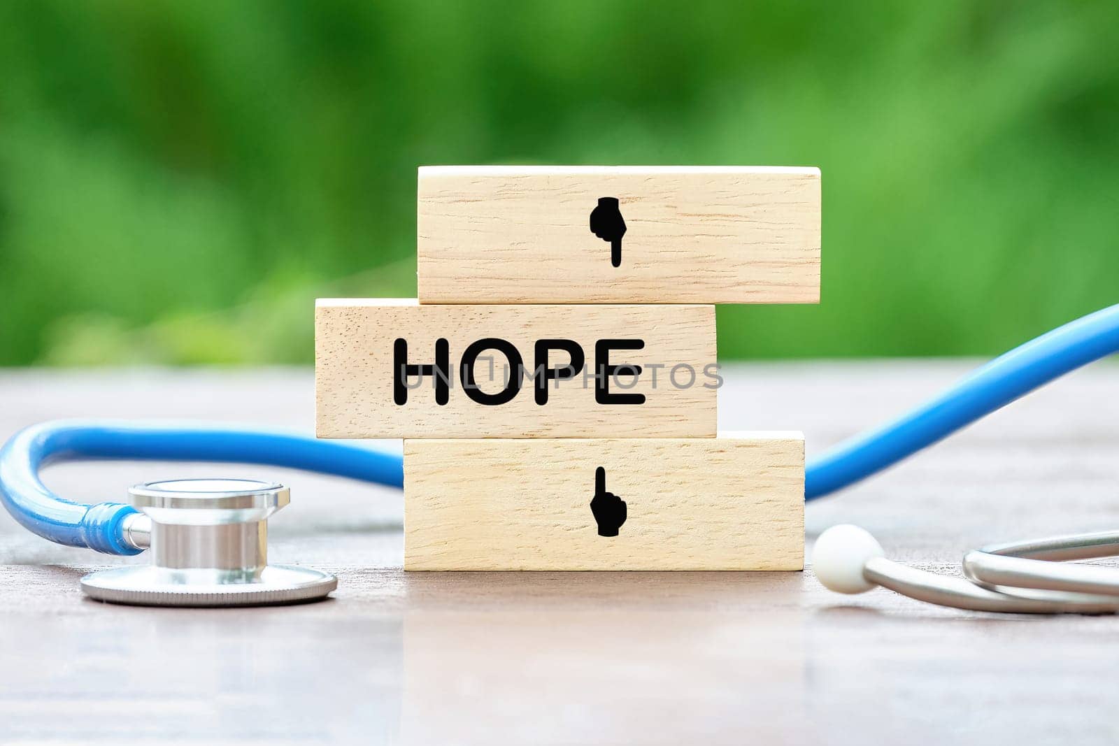 HOPE text on wooden blocks on a green background