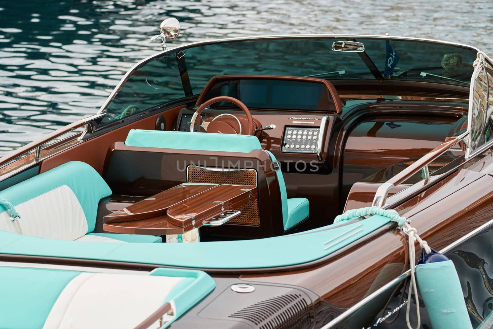 Monaco, Monte Carlo, 29 September 2022 - the wooden side of the luxury motor boat Riva in port of Hercules, sunny glare of the sun, elegance boat, glossy surfaces shine in sunny weather. High quality photo