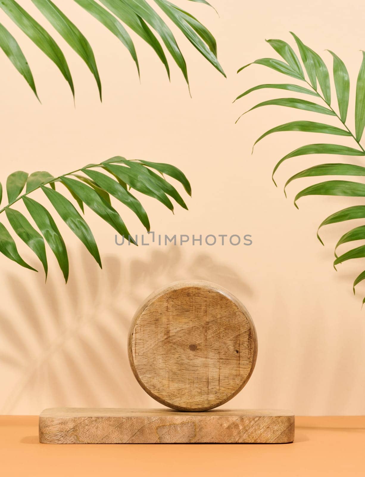 Round brown wooden stand on a white background, a place to display cosmetics  by ndanko