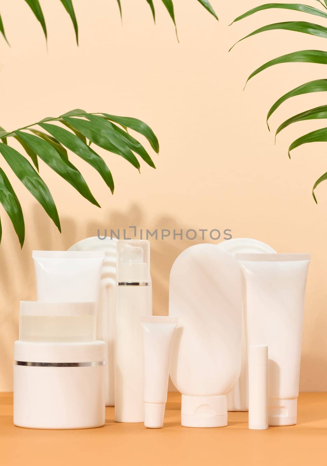 White plastic tubes, jars on a beige background, containers for cosmetic creams and gels, advertising and brand promotion by ndanko