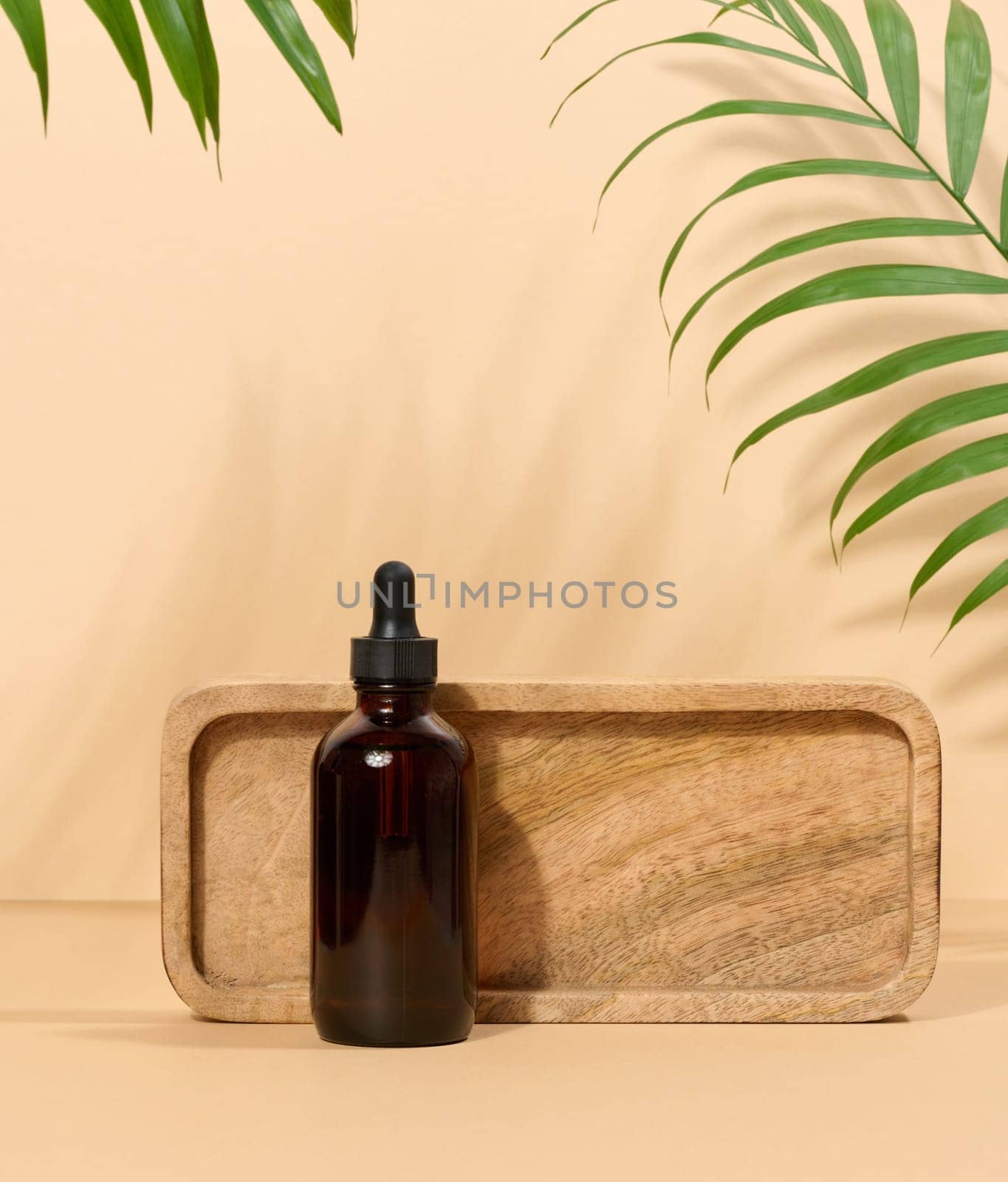 Glass bottle for cosmetics, oils with a pipette on a beige background by ndanko