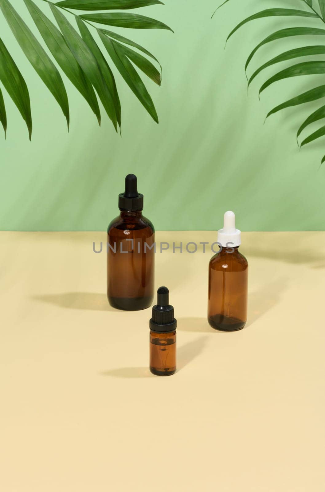 Glass bottles for cosmetics, oils with a pipette on a beige background by ndanko