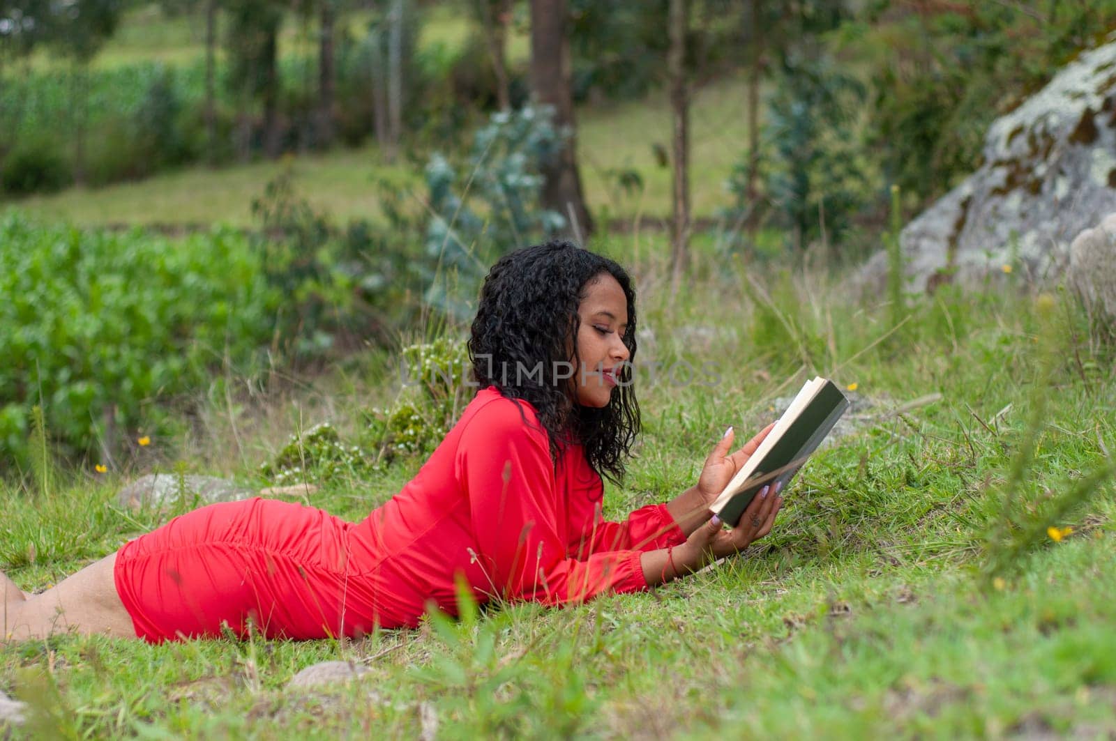 copy space of a south american girl lying next to a rock on a mountain reading a book. book day. High quality photo