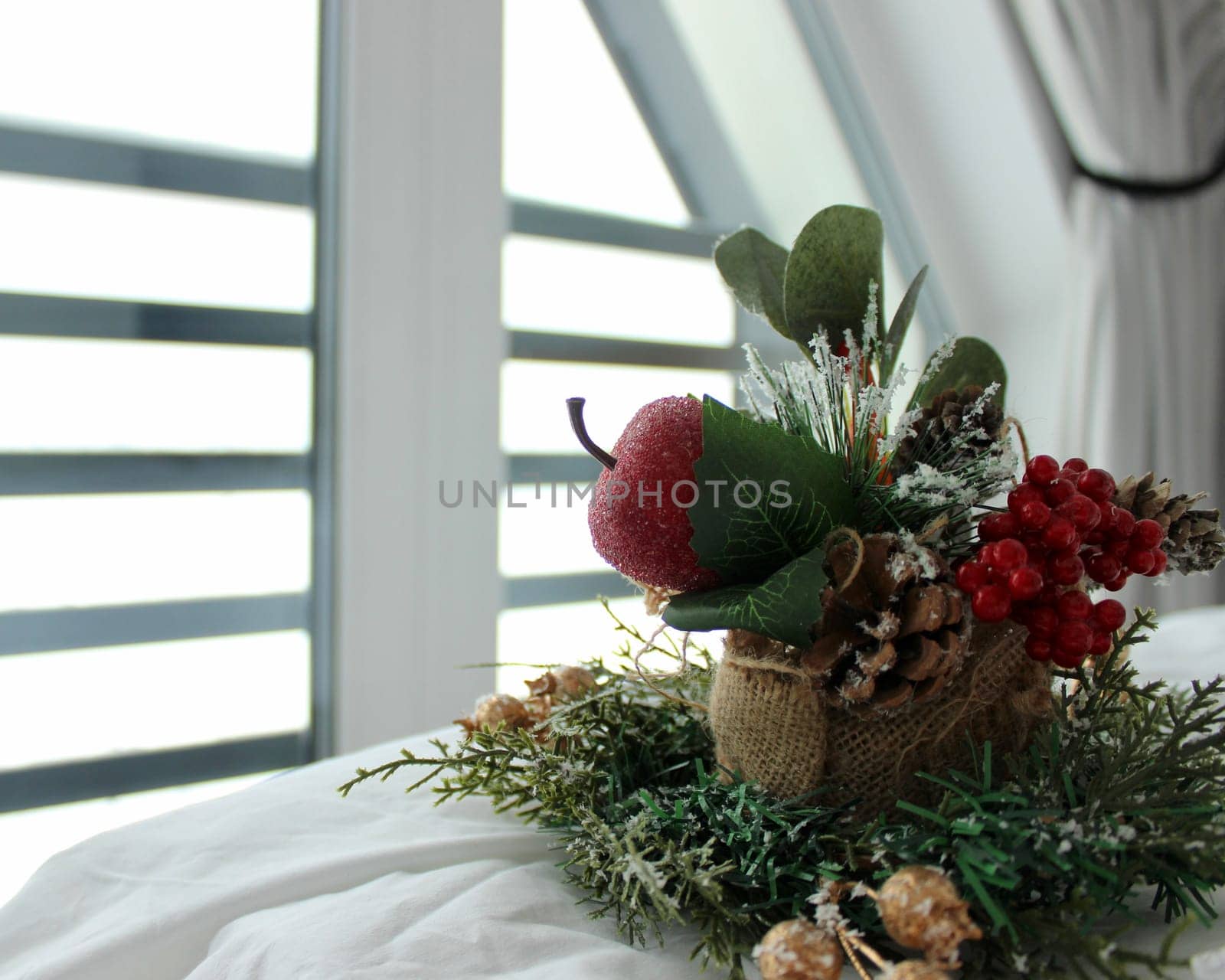 decorative composition on a snow-white bed against the background of a window overlooking a mountainous landscape in winter. High quality photo