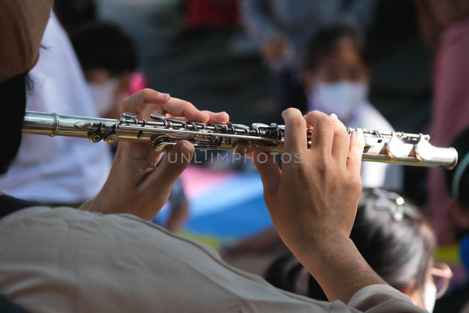 Close-up of the hands of a musician playing the flute. Hands of man playing a flute. by TEERASAK