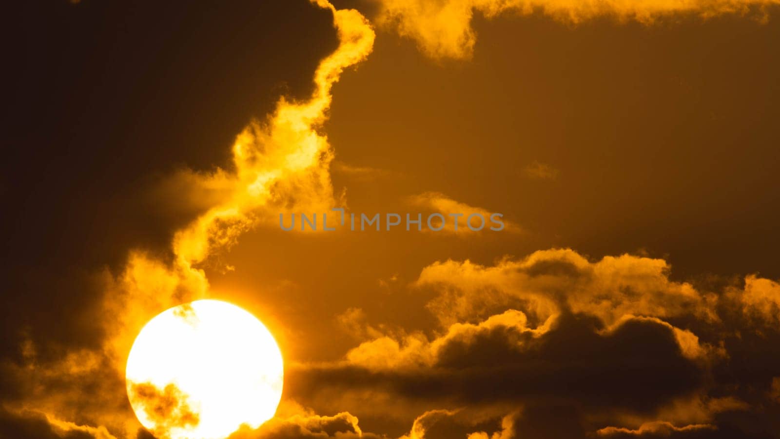 Beautiful nature morning with orange, yellow sunshine and fluffy clouds. Time lapse of a beautiful dramatic sky with a big sun at sunrise.