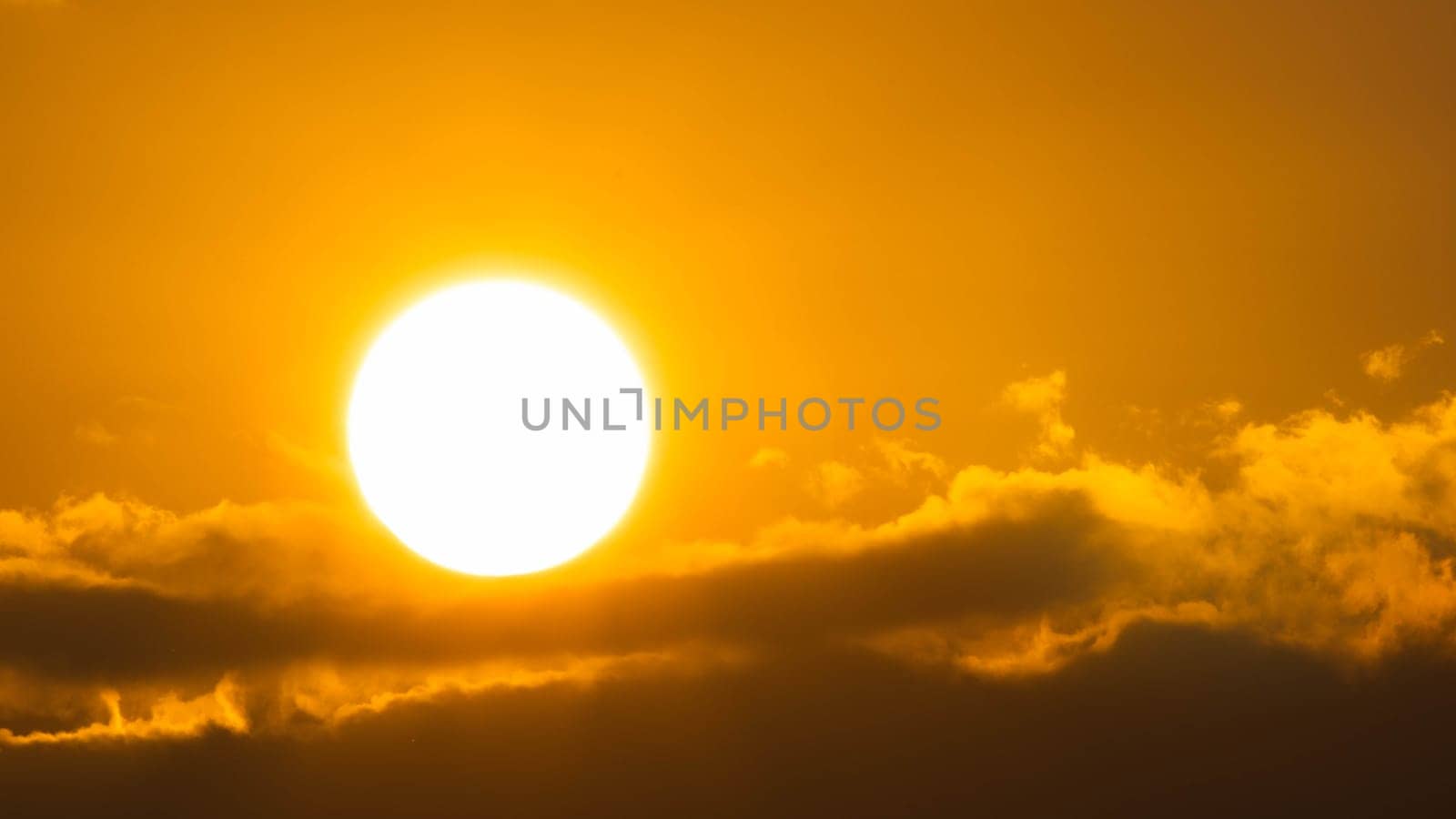 Beautiful nature morning with orange, yellow sunshine and fluffy clouds. Time lapse of a beautiful dramatic sky with a big sun at sunrise.