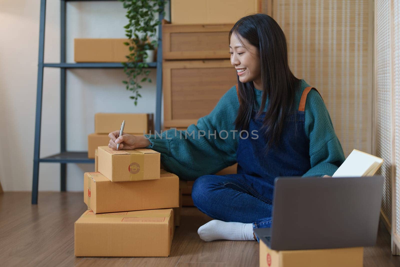 Asian female business owner handles delivery of orders to customers by Manastrong