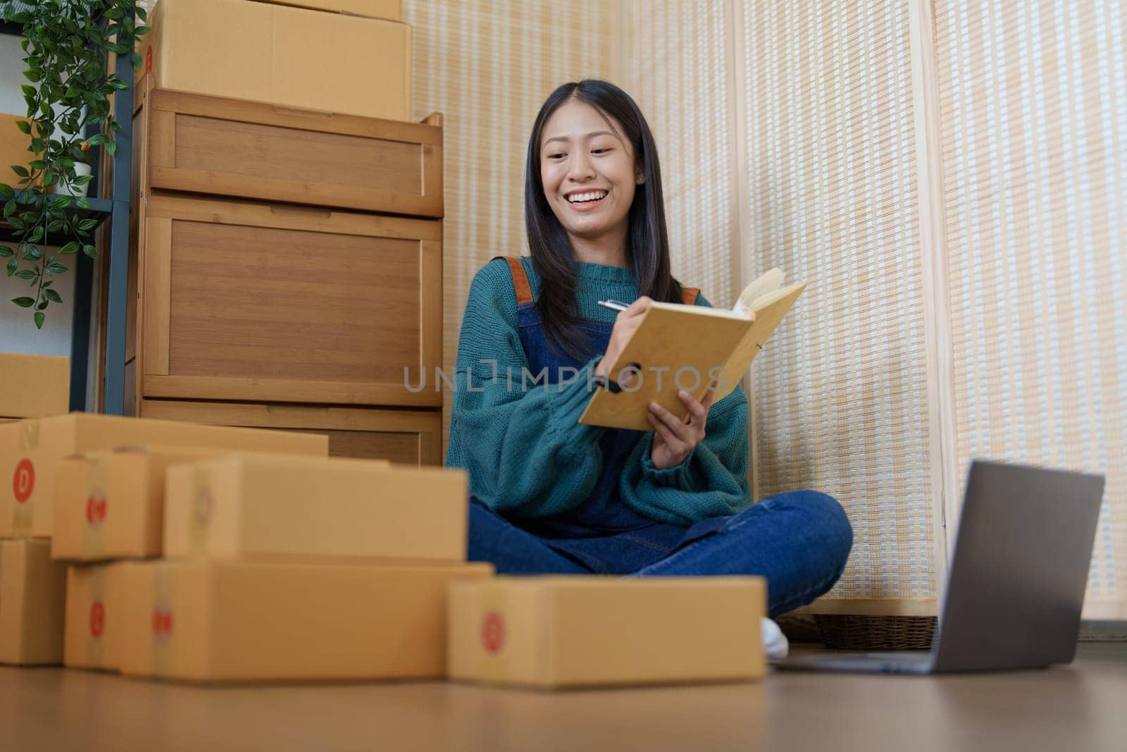 Asian female business owner handles delivery of orders to customers by Manastrong