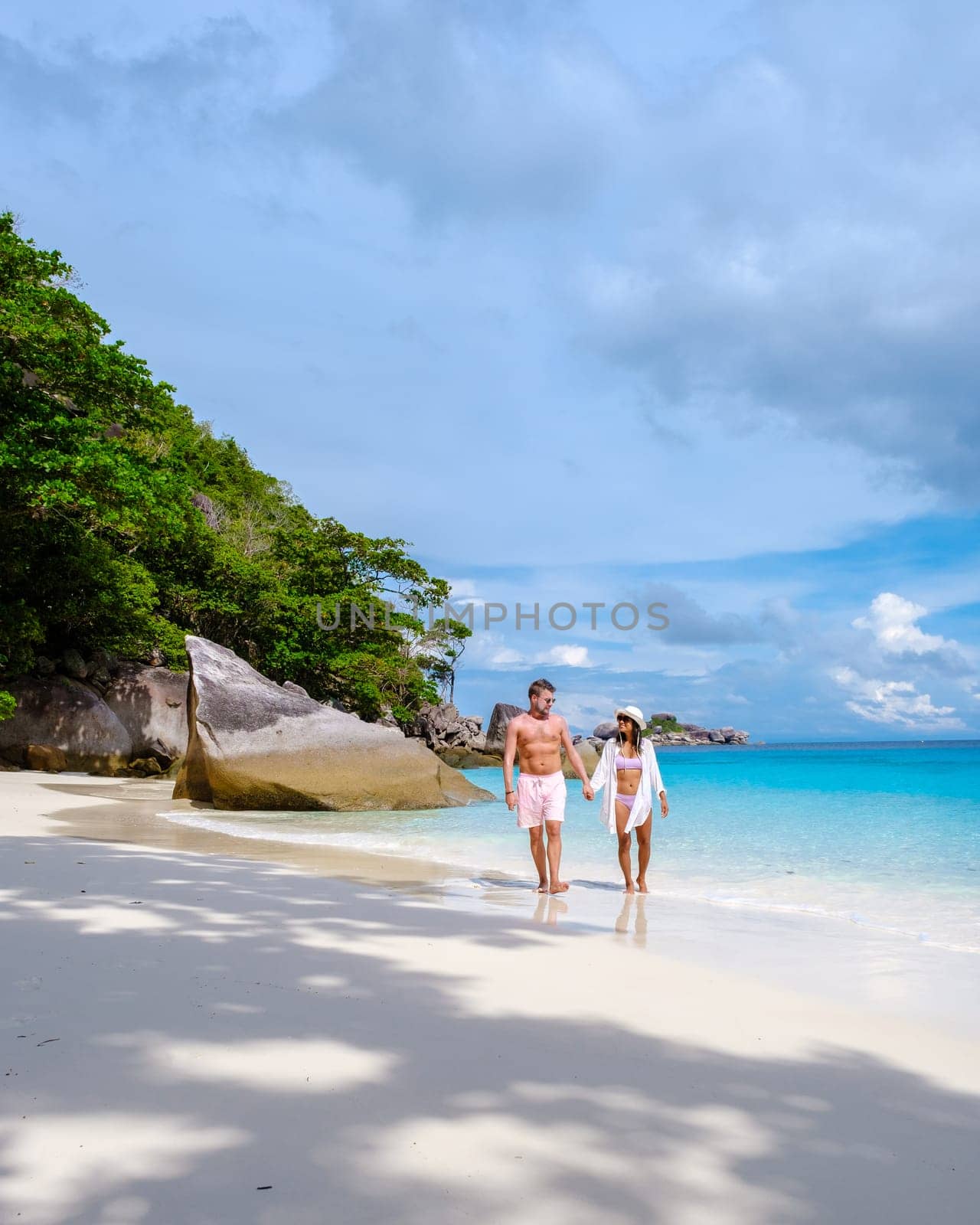 A couple of women and men relaxing on the beach in the sun at the Similan Islands in Thailand Phannga. couple visit the Similan Islands on a boat trip during vacation