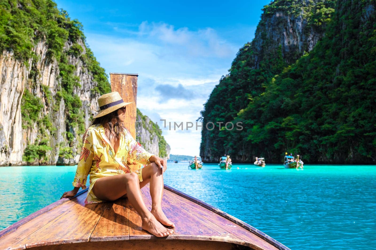 Asian women in front of a longtail boat at Kho Phi Phi Thailand by fokkebok