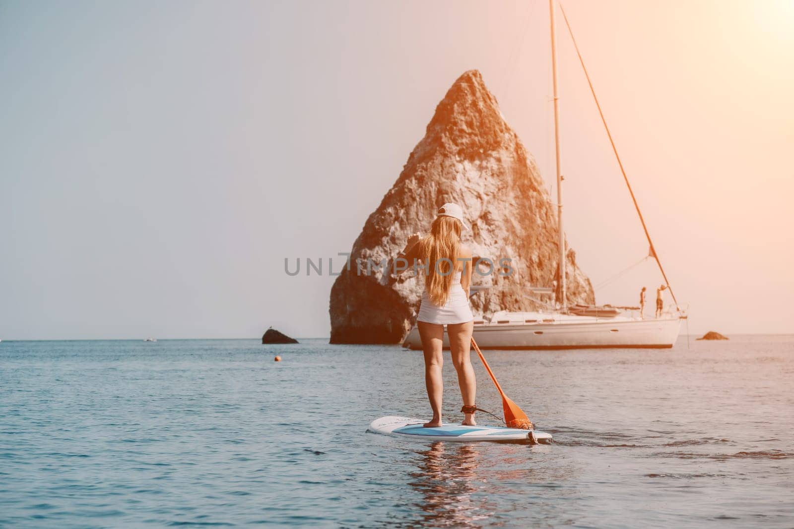 Woman sea sup. Close up portrait of happy young caucasian woman with long hair looking at camera and smiling. Cute woman portrait in bikini posing on sup board in the sea by panophotograph