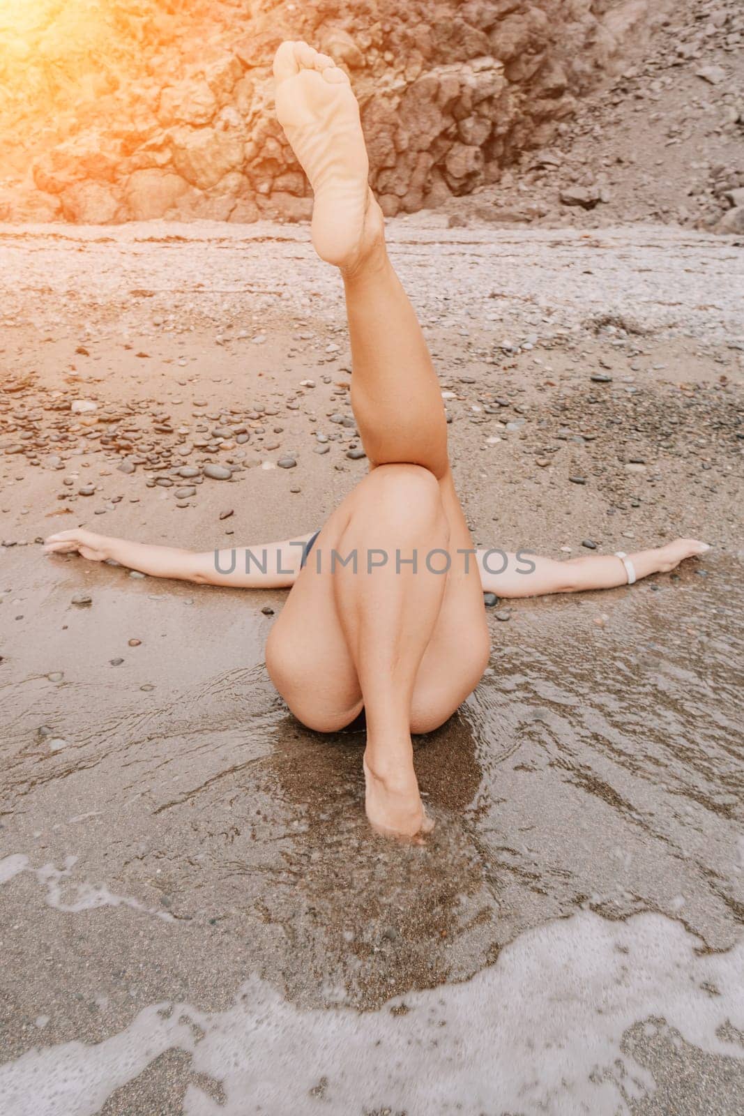 Woman summer travel sea. Happy tourist in blue bikini enjoy taking picture outdoors for memories. Woman traveler posing on the beach surrounded by volcanic mountains, sharing travel adventure journey by panophotograph