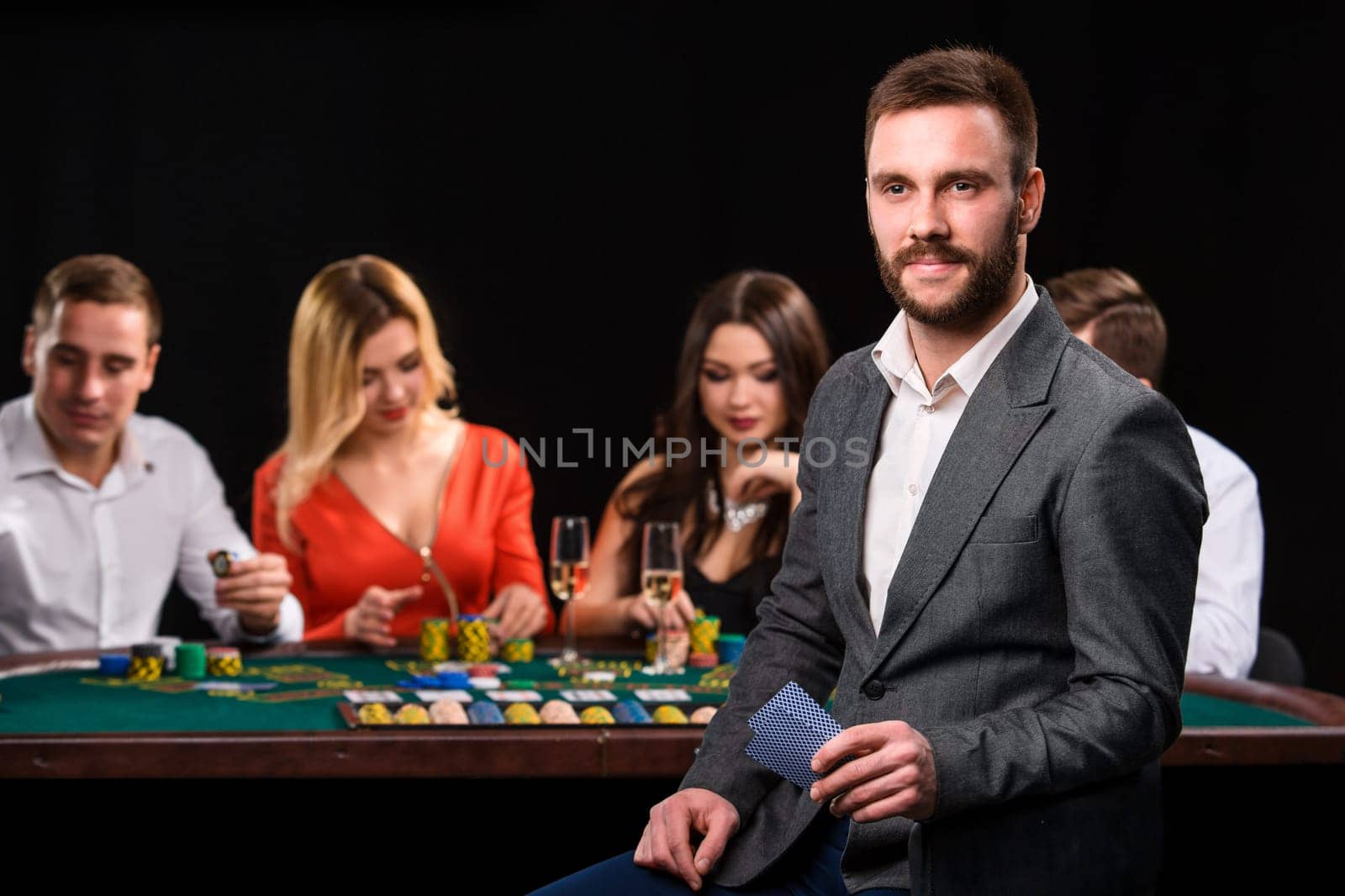 Poker players in casino with cards and chips on black background by nazarovsergey
