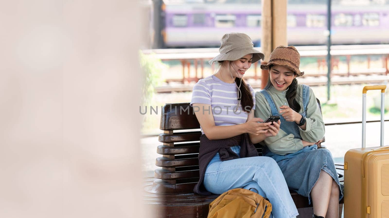 Asian woman friends at railway station have happy moment. Tourism and travel by itchaznong