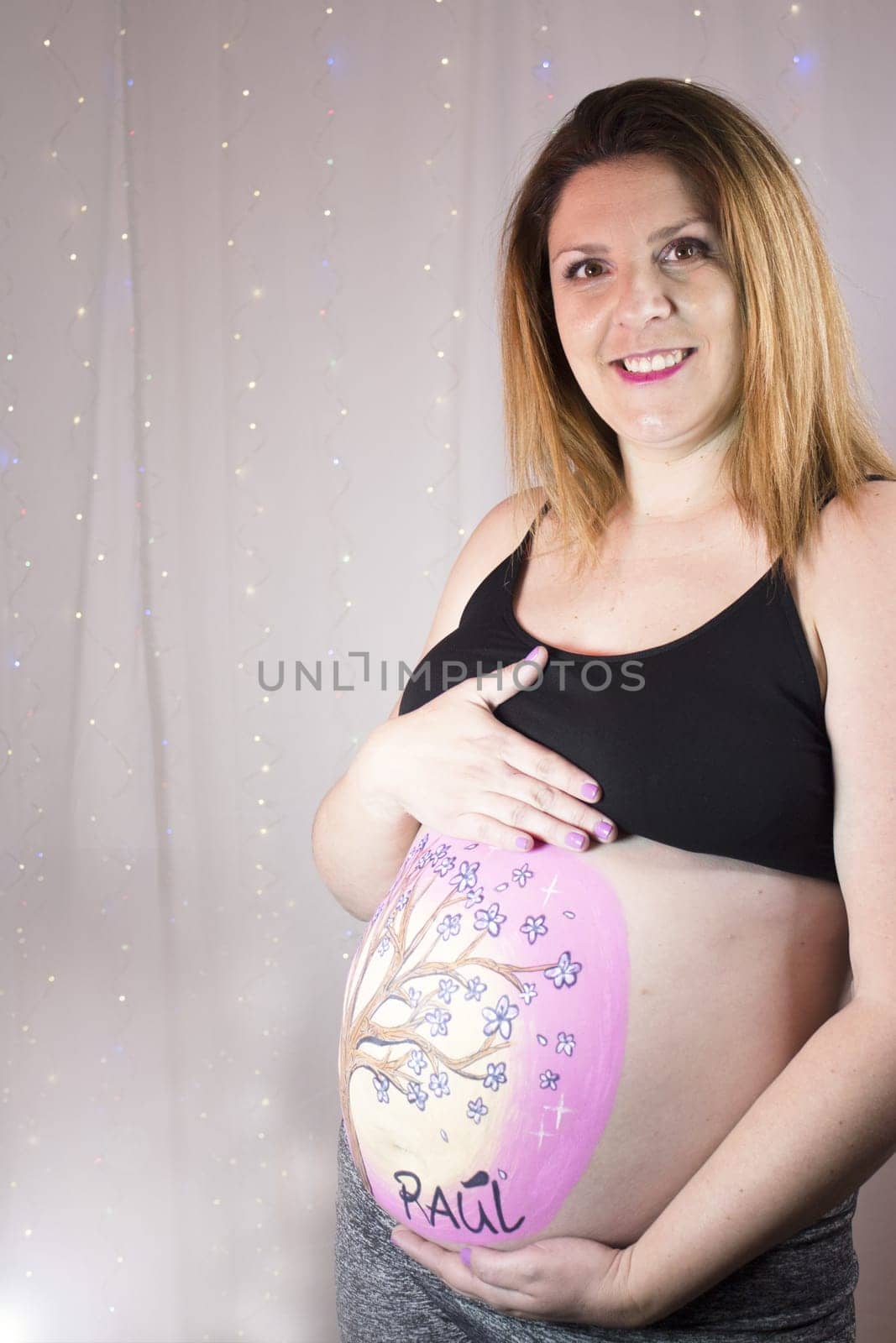 Pregnant woman caressing her belly with drawing. No copy space