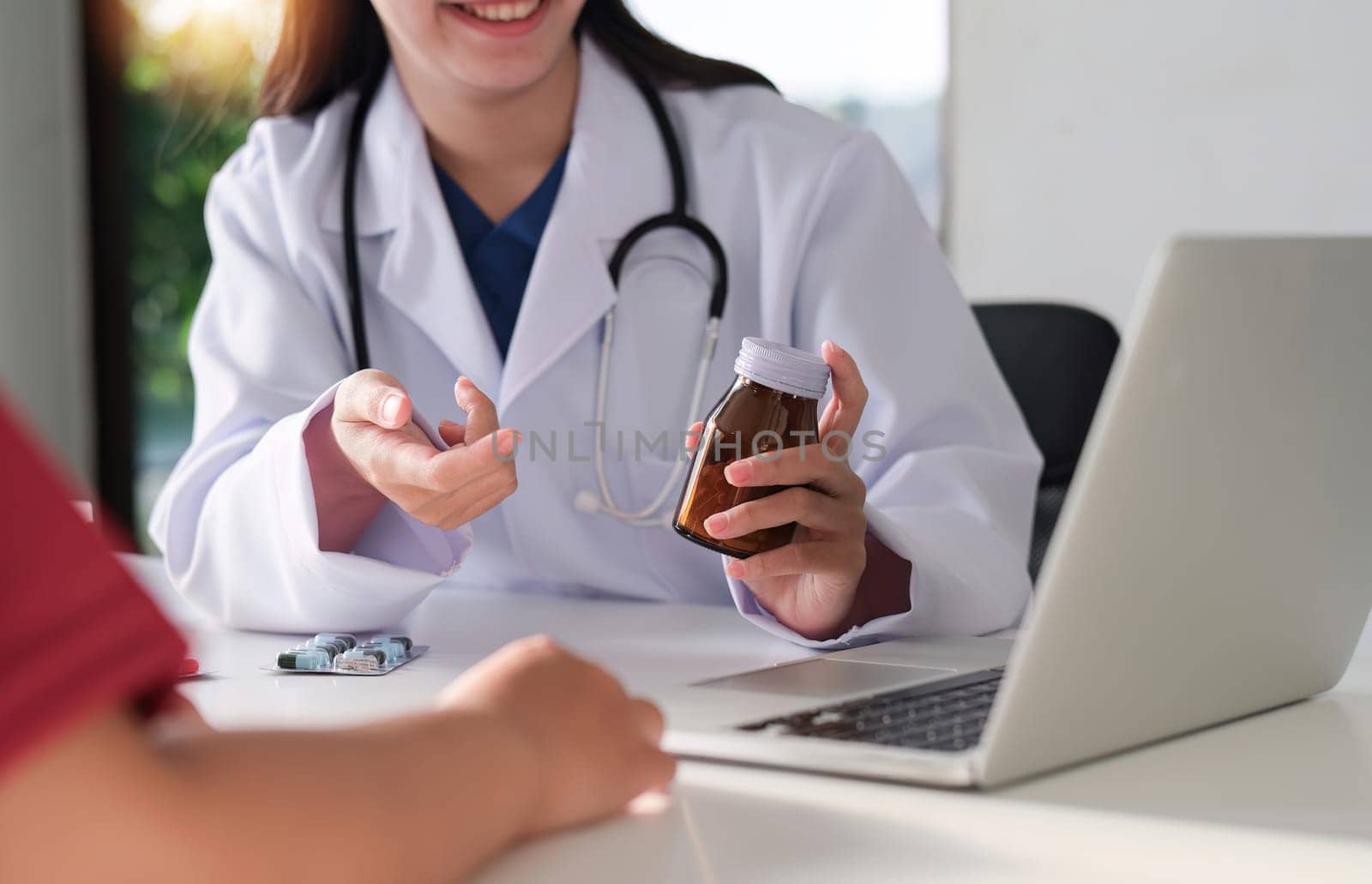 An Asian female doctor is consulting a patient who comes to discuss taking medication for health care. and treat disease with medicine by wichayada