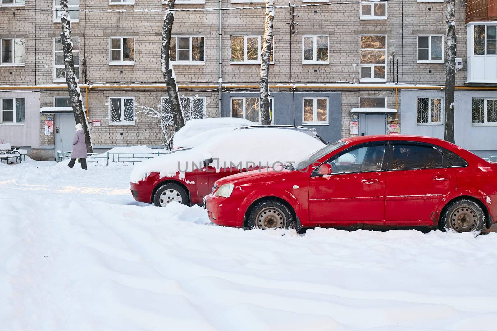 two red cars on ta brick house winter landscape. by electrovenik