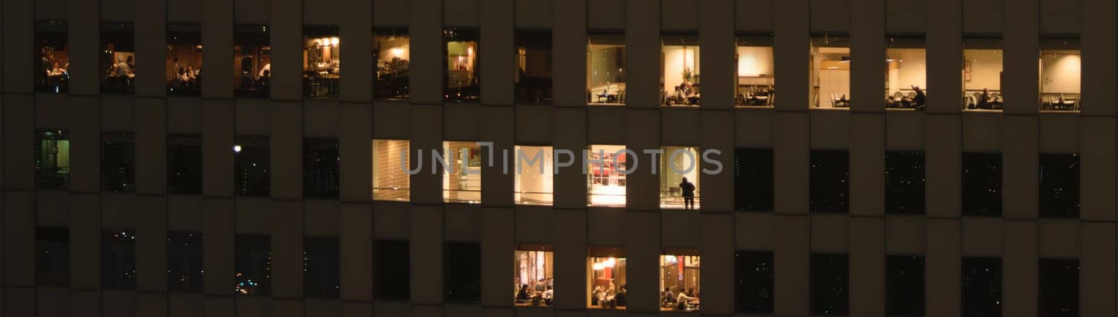 People busy in a skyscraper at night by jameshumble